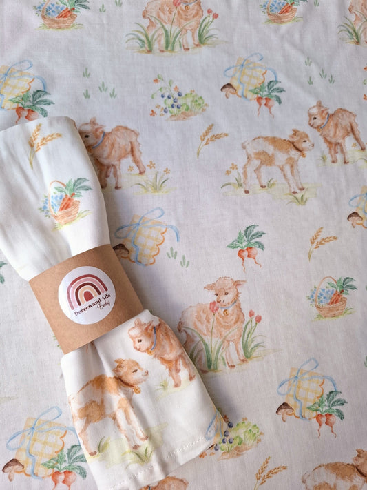 Close-up of muslin square rolled with lambs and vegetable baskets design