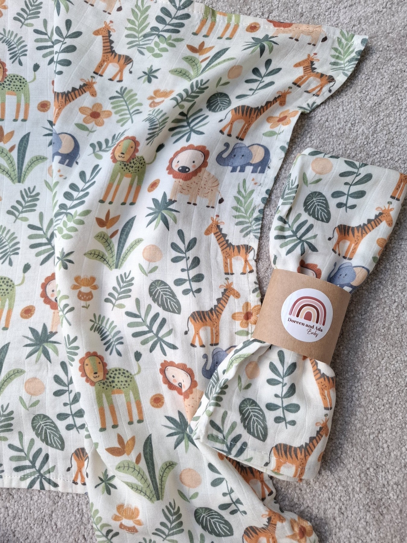 Spread muslin square lying flat with the safari animal pattern visible, next to a folded muslin square showing design details