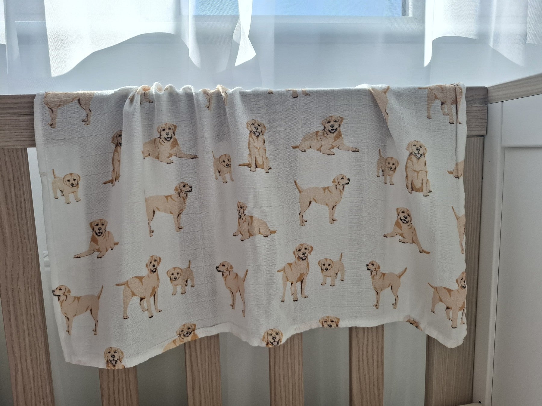 Golden labrador puppies muslin square draped over crèche side showing lightweight fabric