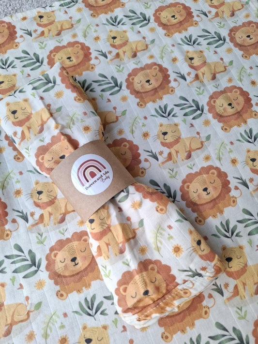 Sleepy lion cub pattern muslin square rolled with label on lion-print fabric