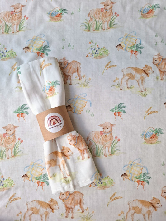 Rolled muslin square with lamb and garden basket design on printed muslin fabric background