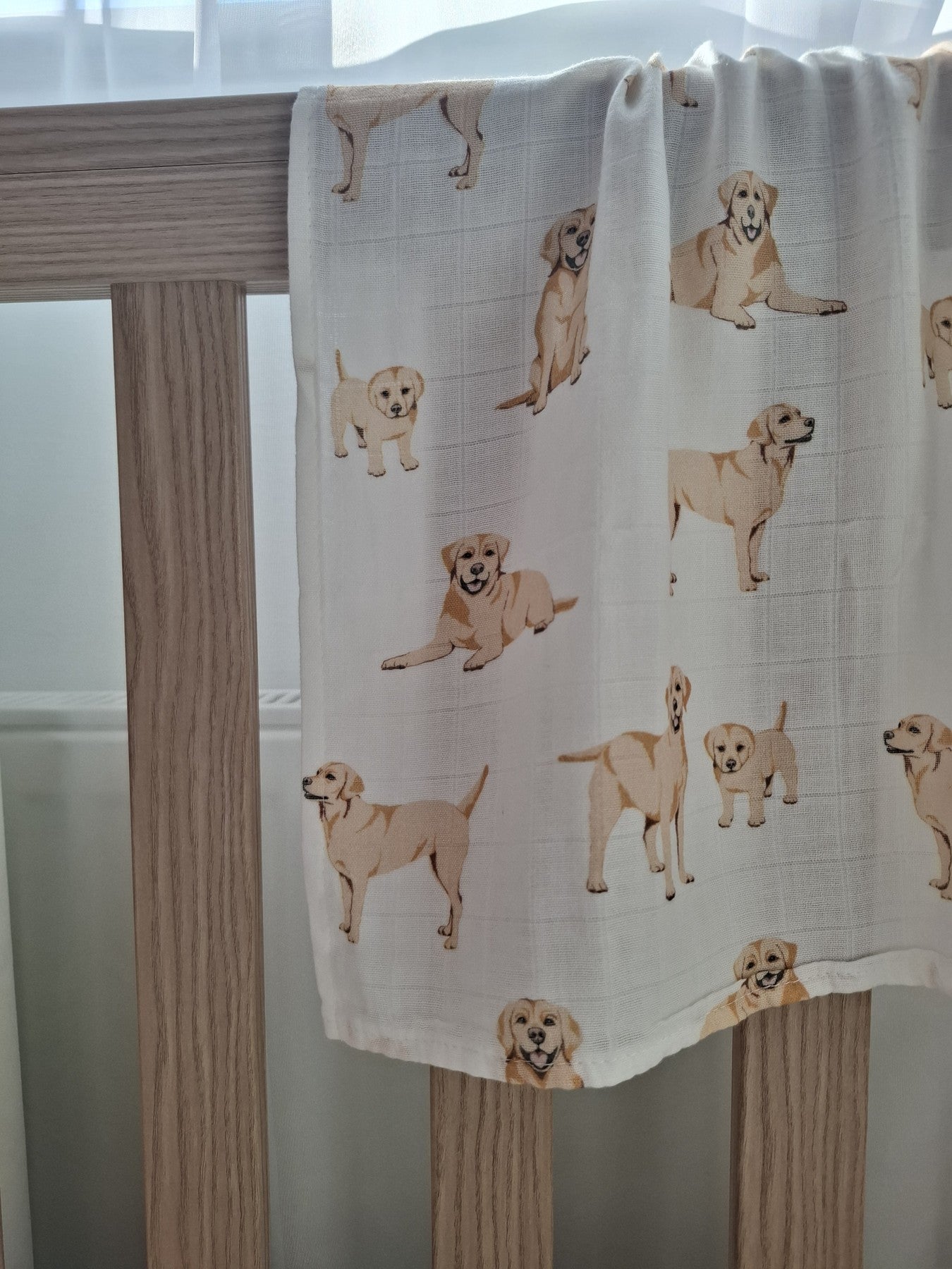 Rolled golden labrador puppies muslin square with label lying on matching muslin cloth