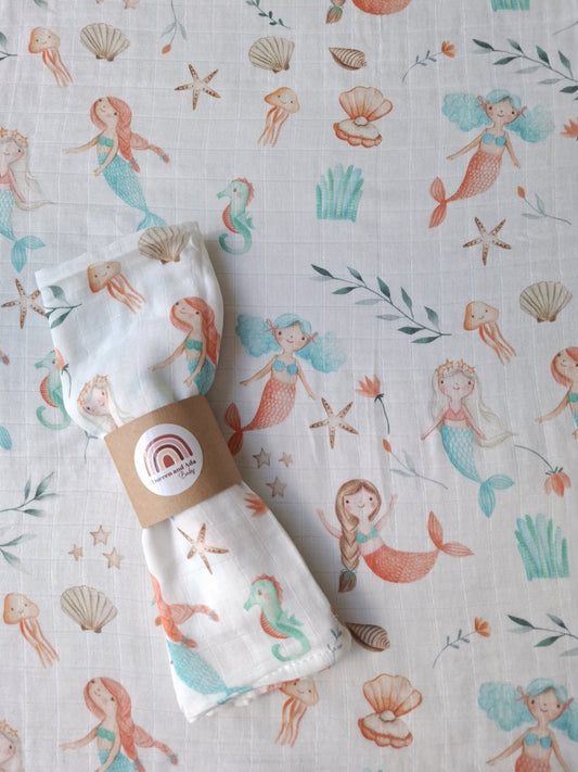 Muslin square and fabric featuring mermaids, seahorses, jellyfish and shells in soft coral and aqua tones