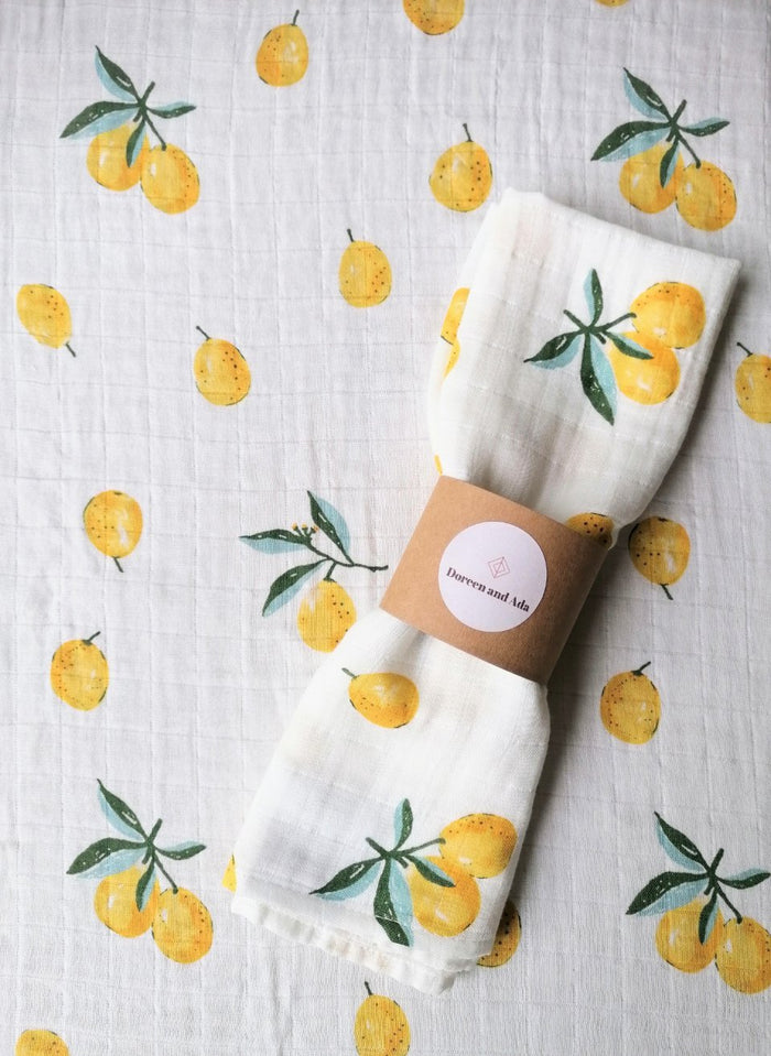 Bright yellow lemon print organic cotton muslin square with citrus fruit design for babies