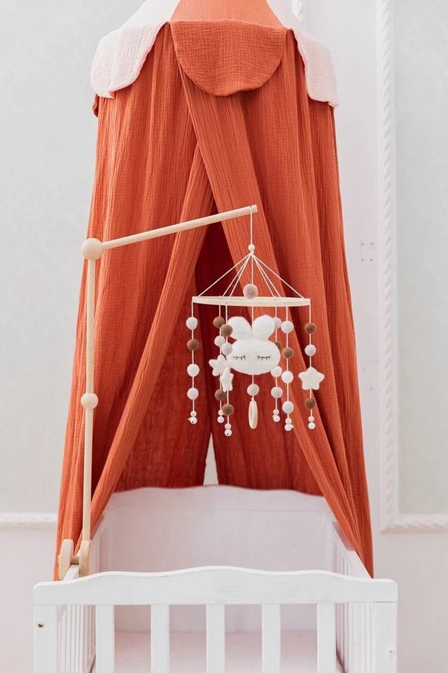 Wooden baby mobile bracket holding mobile above nursery cot